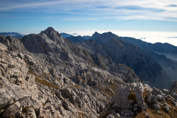 Sunrise on top of a mountain with view into misty valley with fog.