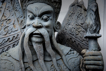 Fototapeta na wymiar A large Chinese cement giant guards the gates of Wat Pho in Thailand.