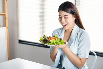 Woman in diet concept with by eating salad.