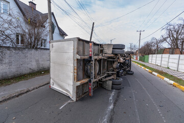 The truck is turned on its side and is lying on the street. Accident.