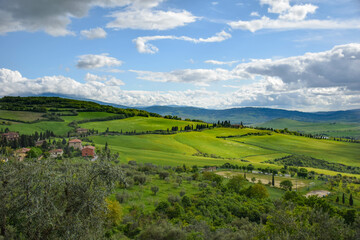 Obraz premium Tuscany, italy, may 2018, a view from a height of a green valley with roads lined with cypress trees and farm houses