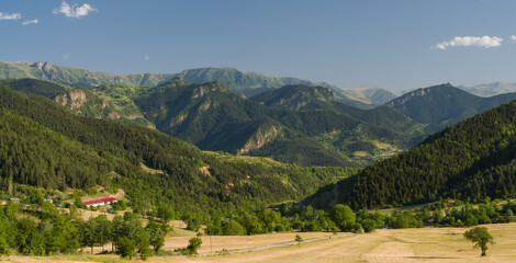 View of the mountains in the summer season. Sunny day in a small village.