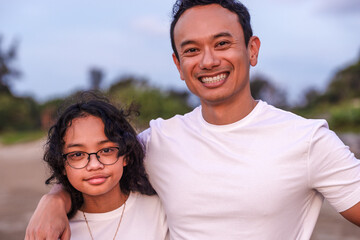 holidays, children and family concept -asian outdoor portrait of dad with his teen daughter