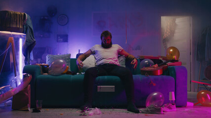 Bearded man sitting on sofa during party
