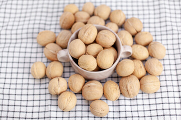 A lot of whole walnuts in a cup on a napkin closeup. Healthy, organic and healthy food with a high content of protein and protein.