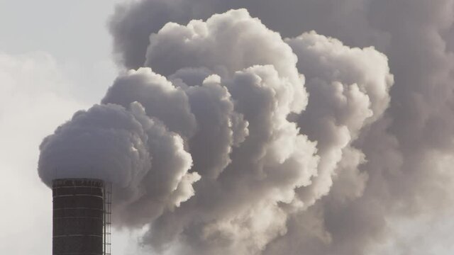 EPIC ZOOM IN to thick billowing smoke from an industrial chimney