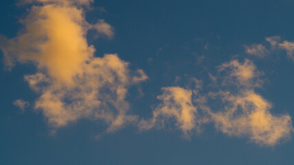 Cumulus fractus, aux teintes orangées, pendant le coucher du soleil