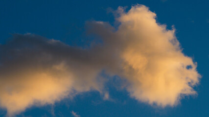 Cumulus fractus, aux teintes orangées, pendant le coucher du soleil