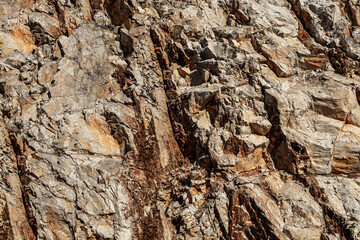 Grungy cragged bumpy pitted cavity stone facade, split layer gap.Ruined cracked shattered worn rough hiking canyon.Old ragged grunge steep marble cliff. Grand vintage crannied damaged impressive gorge