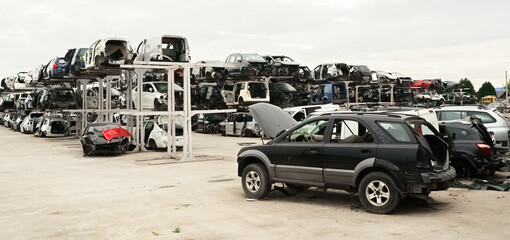 Old rusty corroded and crushed cars in car scrapyard. Car recycling.  Ecological concept by dump of...