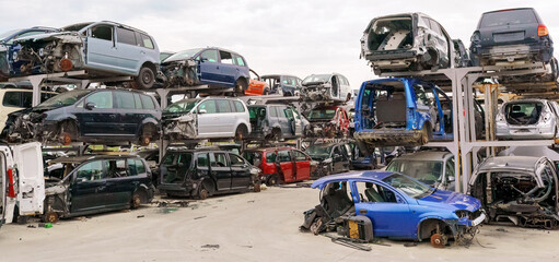 Old rusty corroded and crushed cars in car scrapyard. Car recycling.  Ecological concept by dump of...