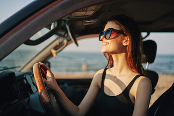 Obraz na płótnie Canvas cheerful woman in sunglasses driving a car trip travel