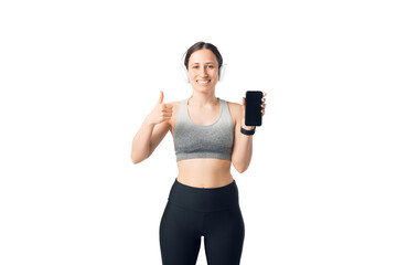 Smiling fit woman, holding mobile phone, and showing thumb up at camera over white background