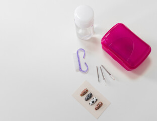 Top view of tools and materials for modern manicure and nail extension on white background and with copy space.