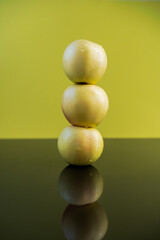 pyramid of yellow apples, green background