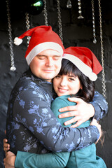 Lovely couple in Santa Claus hats, Christmas vibe family photo