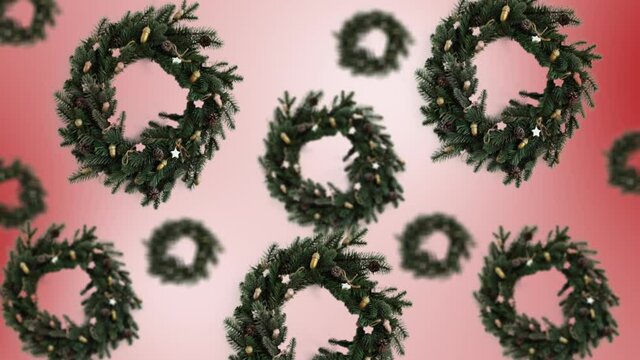 A stream of Christmas wreath decoration of different diameters on a trend color gradient background. 4K UHD footage.
