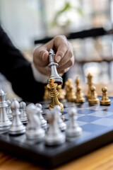 Person playing chess board game, conceptual image of businesswoman holding chess pieces against opponent chess against business competition, planning business strategies to defeat business competitors