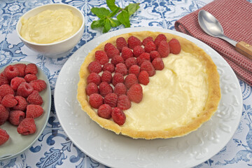 préparation d'une délicieuse tarte aux framboises entières, ingrédients sur table