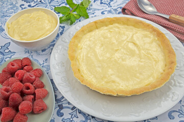 préparation d'une délicieuse tarte aux framboises entières, ingrédients sur table