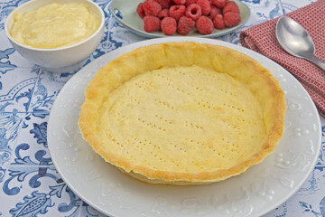 préparation d'une délicieuse tarte aux framboises entières, ingrédients sur table