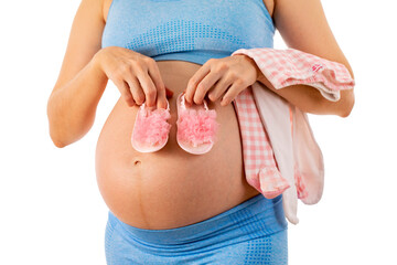 pregnant woman tries on baby clothes on her belly. woman on white background. 