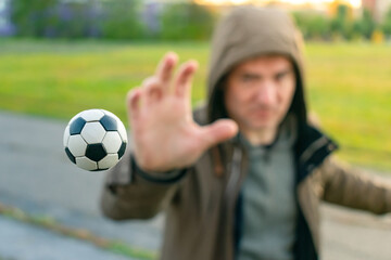 Naklejka premium The soccer ball flying in the air, the athlete catches with his hand. Man throws the ball with his hand