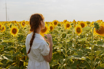 woman with pigtails in a white dress admires nature landscape