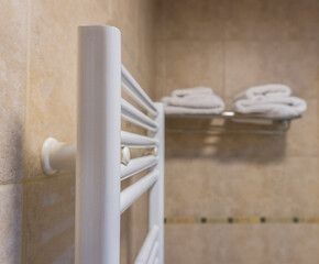 Fototapeta na wymiar Bathroom towel warmer with towels in the background