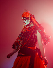 Young woman in calavera style with Mexican skull make-up on her face