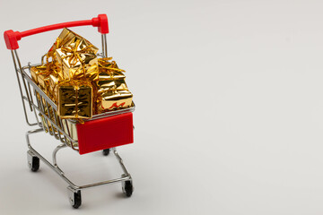 Black Friday concept. Shopping cart on the table. Metal shopping cart with wheels on a white...