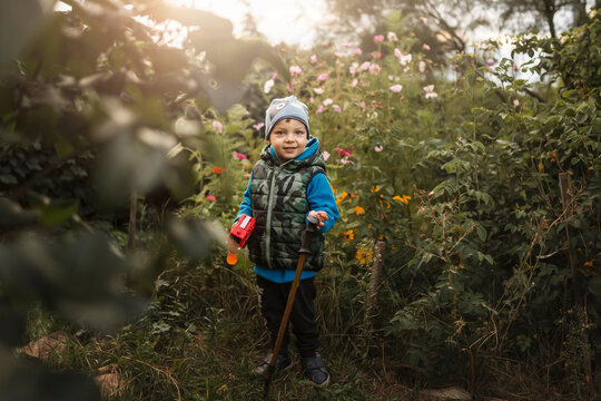 Toddler boy standing in flower garden