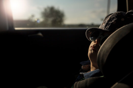 Boy Napping In Car Seat With Sunglasses On