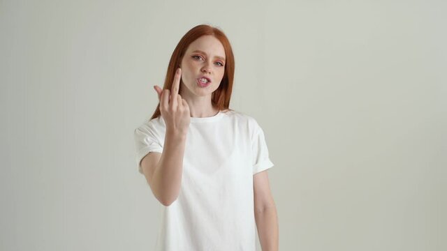 Portrait of excited annoyed young woman showing middle fingers on both arms, gesture of disrespect and hate, rude fuck off expression. Rude and rude lady showing middle finger looking at camera.