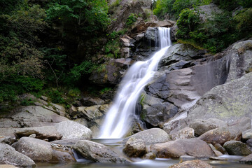 Fototapeta premium Small waterfall on an Italian stream, surrounded by nature
