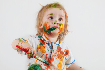 The child, who was messy drawing his face and clothes, looks up in surprise