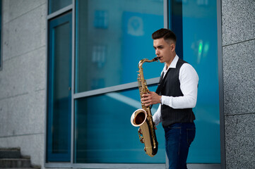Saxophonist plays melody at the stairs on street