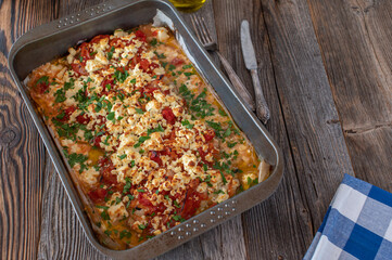 Oven baked fish dish with redfish, tomatoes, onions, feta cheese, olive oil and parsley. Greek recipe Psari Plaki