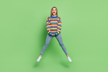 Full length body size photo girl in striped sweater jumping up careless childish isolated pastel...