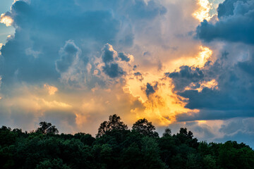 Obraz na płótnie Canvas Clouds at sunset over trees