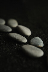 Fototapeta na wymiar small sea pebbles are laid out on a black background