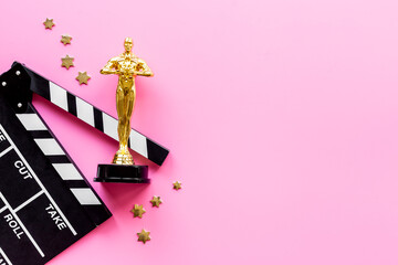 Movie clapper board with golden film award statue