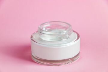 Bottle with cosmetic cleanser on pink background. Skin care concept.