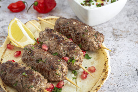 Traditional homemade kafta or kofta kebab with tomato sauce and yoghurt
