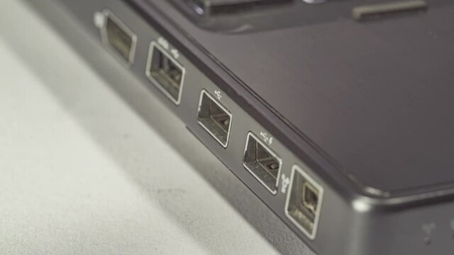 Close up of hand inserting plugging data cable into usb port in laptop 2