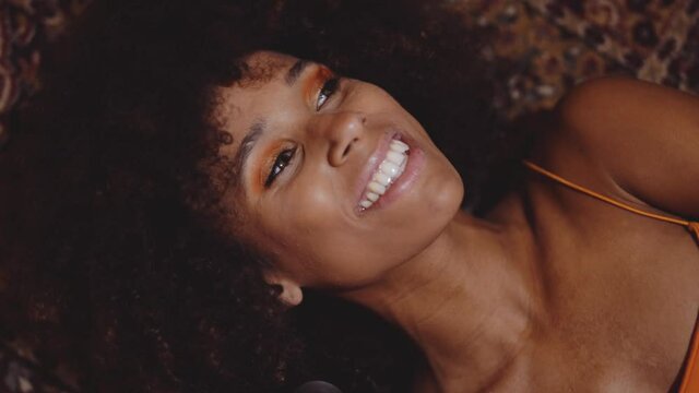 Woman With Afro Hair Lying On Floor With Vintage 8Mm Camera