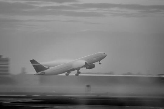 Airplane taking off in a foggy early morning from Schipol International Airport