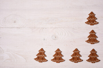 Gingerbread cookies in shape of a Christmas tree on white wooden deck. Flat lay, top view, copy space. New Year frame.