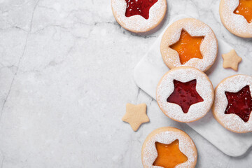 Cooking Christmas background with traditional cookies. Linzer cookies with red and yellow jam