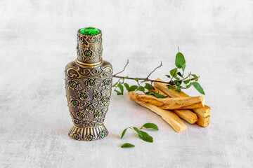 Agar wood tree oil perfume in silver bottle with sticks of tree